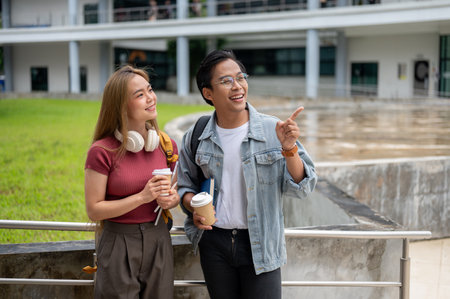 Two happy young Asian college students in casual clothes are excited on their first day, enjoying the view of the building while walking outside. back to school, freshmen, educationの写真素材