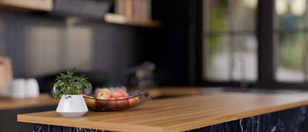 A close-up of a display space on a modern wooden kitchen island featuring a decorative plant and a plate of apples in a sleek black kitchen. 3d render, 3d illustrationの写真素材