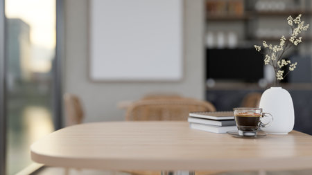 A close-up wooden table by the window in a contemporary and comfortable coffee shop features a...