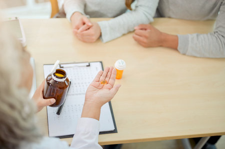 A close-up of a doctor explaining the instructions for the medication to a patient during the visit in an examination room. health care conceptの写真素材