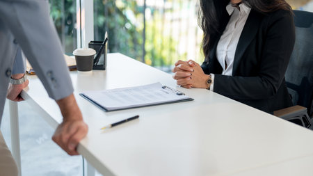 A close-up image of an Asian woman during a job interview with a male CEO in an office. job interview, recruitment, career, occupationの写真素材