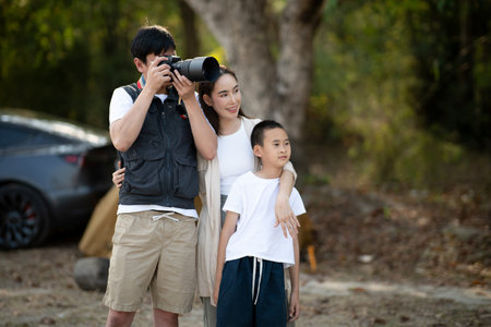 The mother and son is looking at the scenery while the father is taking a photo. Family trip, Sightseeing, Going Camping, Outdoor activity.の写真素材