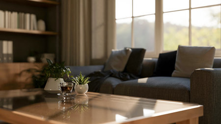 A coffee cup and potted plants on a glass top wooden table with fabric sofas in the living room or study room. 3d rendering, 3d illustrations.の写真素材