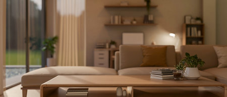 A wooden table with books, a coffee or tea cup and potted plants aside next to a fabric sofa in a...