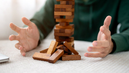 Close up a man's hands open palms aside pieces of wooden block in tower building game playing alone. Party game, Development toys, Learning activity.の写真素材
