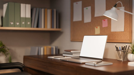 Blank screen laptop with books and pencil on wooden table aside bulletin board in study office room. Advertising Mockup, 3D rendering, 3D Illustration.の写真素材