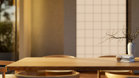 Coffee in glass cup with book and vase on wooden dining table with armchairs in warm sunlight....