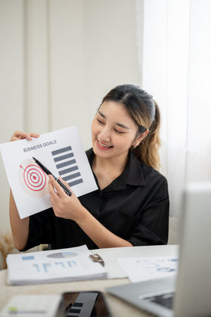 Asian businesswoman or office worker pen pointing on document to an online meeting via laptop on...