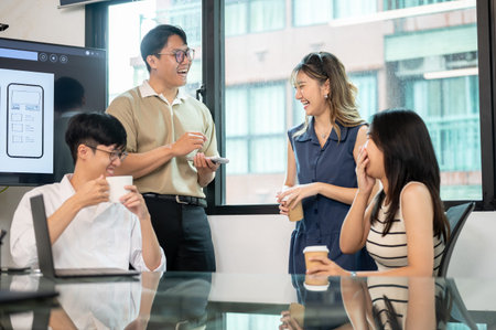 Asian men and women coworker laughing and talking together after presentation in office meeting...