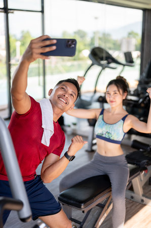 Fitness trainer coach man taking picture photo on phone with woman client after exercising in a gym....