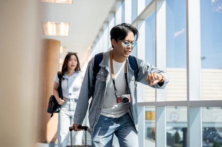 Asian tourist couple man and woman hurry rushing to check in running late for flight time in...