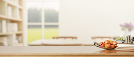 Apple on glass plate with book and pencil on wooden counter table across window in white living...