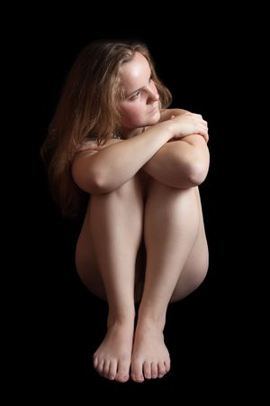 Sitting nudity girl.  Isolated on black backgroundの写真素材