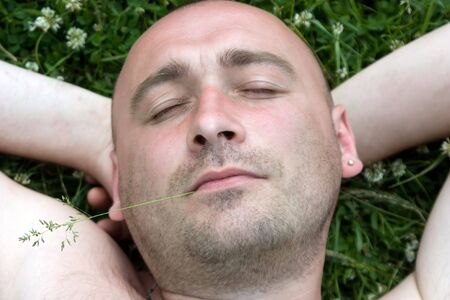 Fum man rest on green grass during summer dayの写真素材