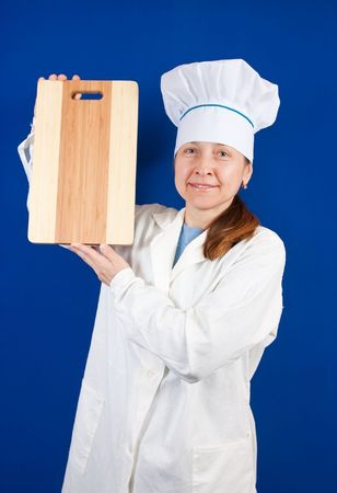 smiling cook holding cutting board  over blue backgroundの写真素材