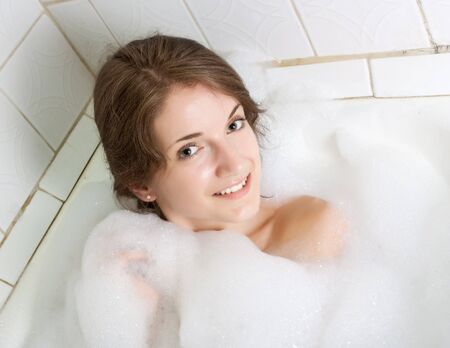 young beautiful girl in a bath with  foam