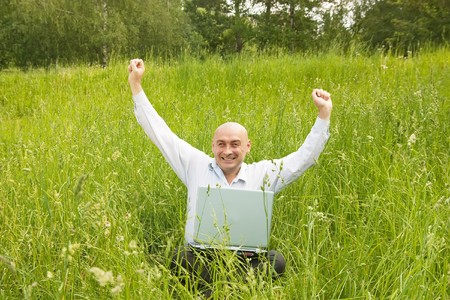 Young businessmen relaxing with grey laptop outdoorの写真素材