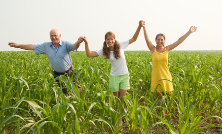 Beautiful cheerful family  go for a walk over a field の写真素材
