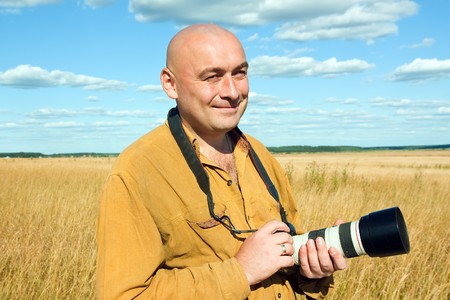 Adult man taking picture with digital camera over summer nature