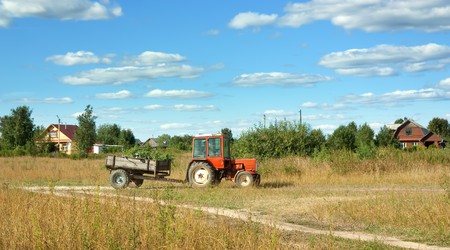  Tractor on meadow grass in summer dayの写真素材
