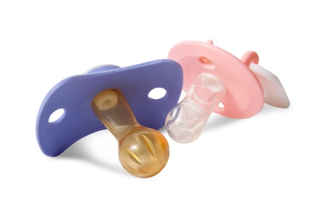 Photo of blue and pink pacifiers on white backdrop 