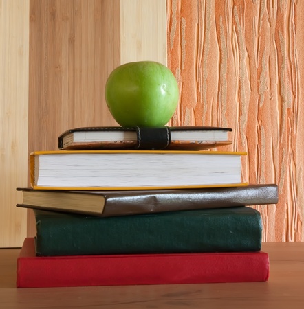 Heap of differents book on table with appleの写真素材