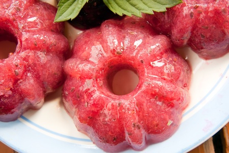 Sweet raspberry jelly on a wooden table with mint