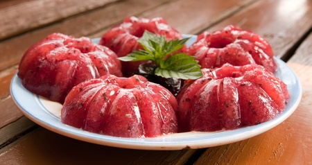 Sweet raspberry jelly on a wooden table with mint