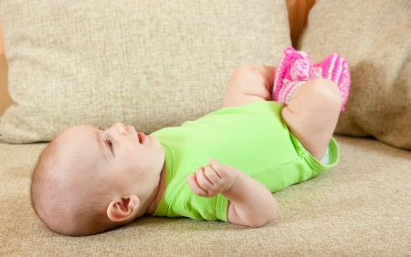 Portrait of cute little baby girl on sofaの写真素材