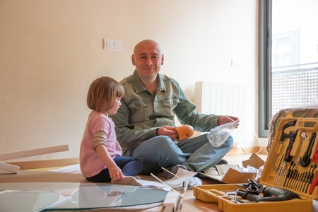 Adult man and little girl assembling   coffee tableの写真素材