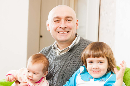 Dad and two daughters sitting on   couch の写真素材