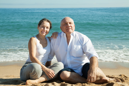 Happy mature couple together at sea beachの写真素材