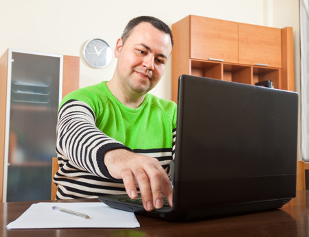  man  sitting at work on laptop at home.の写真素材