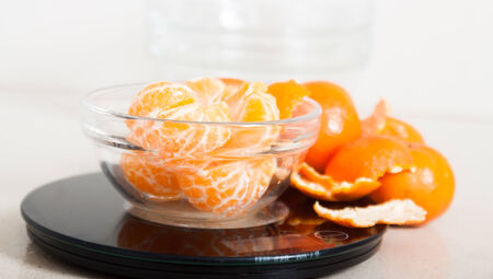 peeled mandarins 	on black scales on  table の写真素材