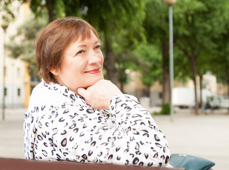Outdoor portrait of smiling mature woman at european town streetの写真素材