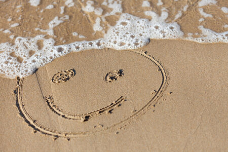 funny face  drawning  on  sand near  seaの写真素材