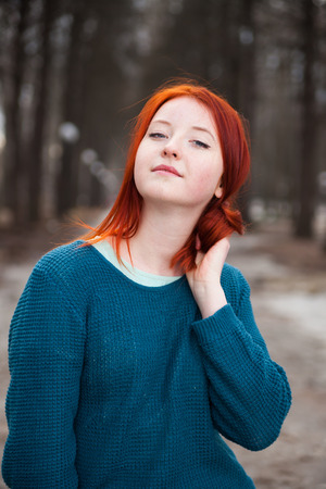 Cute red-haired girl in   park in spring day.の写真素材