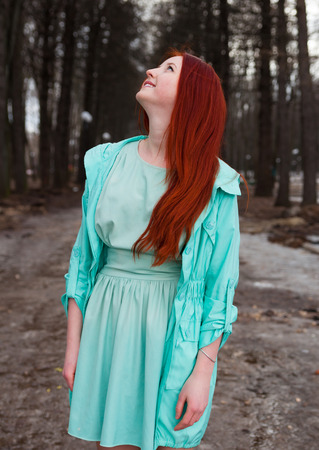 Cute red-haired girl in   park in spring day.の写真素材