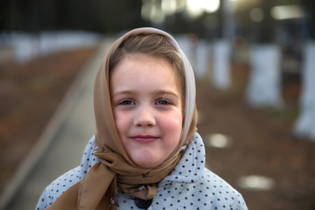Cute little girl in scarf on her headの写真素材