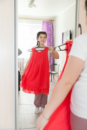 girl   trying  on  dress   in front of   mirrorの写真素材