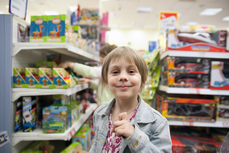 Little girl in   toy store choosing   toysの写真素材