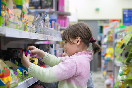 Little girls choosing what to buy in   toy storeの写真素材