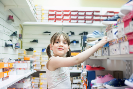   schoolgirl choosing   shoes for school. の写真素材