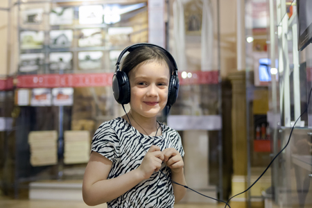 girl listening to interesting information about exhibit through headphones.の写真素材