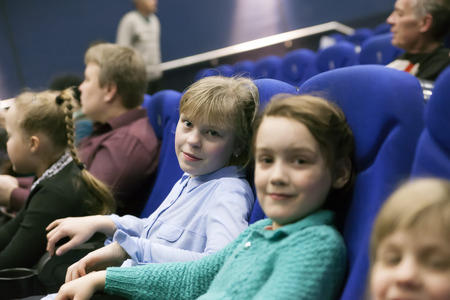   children sitting in   cinema and waiting for   show. の写真素材