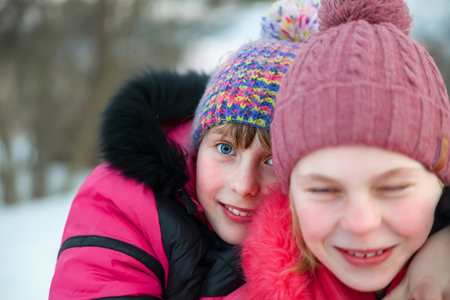 Two girls  of 10 years old in winter  park   . の写真素材