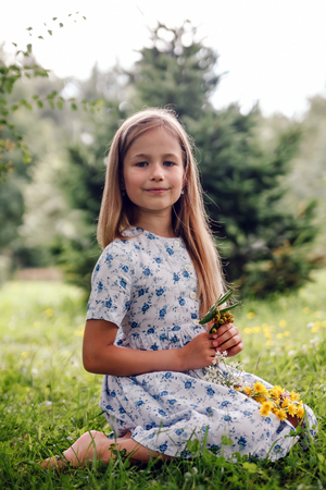 Portrait of   8 years old girl in   park with flowersの写真素材