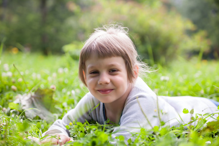 portrait of five year old girl in green grassの写真素材