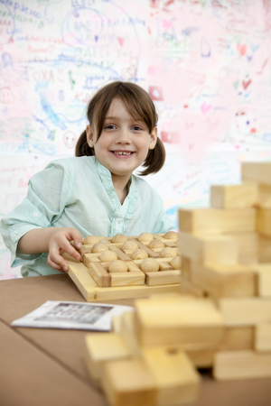 Cute schoolgirl playing with wooden puzzles. の写真素材