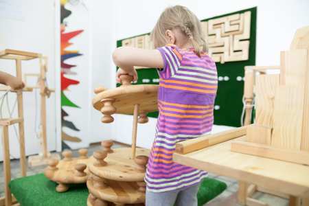 Girl of 5 years collecting   wooden puzzle in   playroom.の写真素材